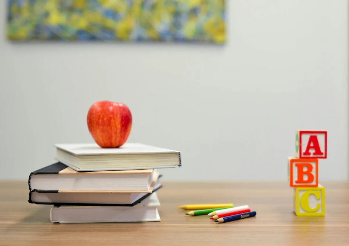 Books, an apple, and alphabet blocks on a desk